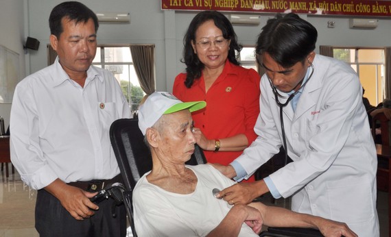   Đoàn Từ thiện Hội Chữ thập Đỏ bệnh viện Hùng Vương khám bệnh cho người già khuyết tật xã Kim Long. Ảnh: Hồng Huê - Quang Việt