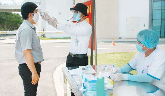 Người bệnh và người nhà bệnh nhân được  đo thân nhiệt, khai báo y tế ngay từ cổng bệnh viện Ảnh: MINH NAM