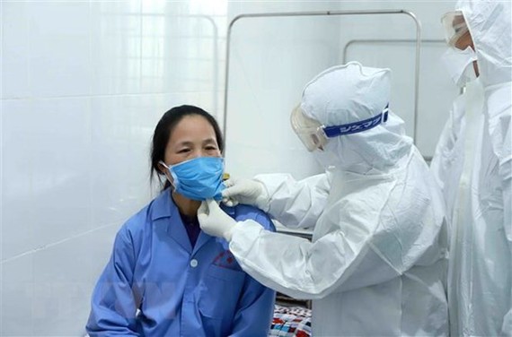 Bác sỹ Đội cơ động Bệnh viện Bạch Mai (Hà Nội) thăm khám cho bệnh nhân tại Trung tâm y tế huyện Bình Xuyên, Vĩnh Phúc. (Ảnh: Hoàng Hùng/TTXVN)
