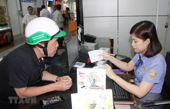 Nhân viên tại Ga Sài Gòn hướng dẫn hành khách thủ tục mua vé tàu. (Ảnh: Tiến Lực/TTXVN)
