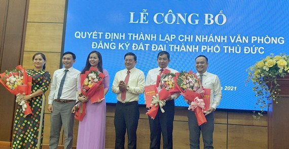 Ông Nguyễn Hữu Anh Tứ, PCT UBND TP Thủ Đức  (thứ 2 từ trái qua) và ông Nguyễn Toàn Thắng, Giám đốc Sở TNMT  (thứ 4 từ trái qua) chúc mừng Ban giám đốc Chi nhánh văn phòng ĐKĐĐ TP Thủ Đức.