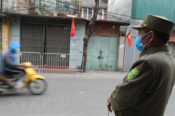 Lực lượng chức năng tiến hành lập chốt tại khu vực có ca nghi nhiễm COVID-19 tại Hà Nội. (Ảnh: Minh Quyết/TTXVN)