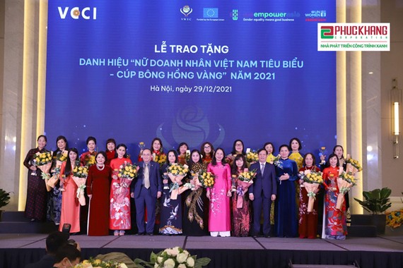 Phó Chủ tịch nước Võ Thị Ánh Xuân và ông Phạm Tấn Công - Chủ tịch Phòng Thương mại và Công nghiệp Việt Nam (VCCI) tặng hoa và cúp cho các nữ doanh nhân
