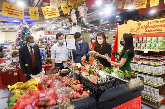 Bà Goh Tsu Ching (thứ 2, từ phải sang), Giám đốc cung ứng quốc tế FairPrice, giới thiệu các mặt hàng trưng bày tại Tuần lễ hàng Việt Nam. (Ảnh: Lê Dương/TTXVN)