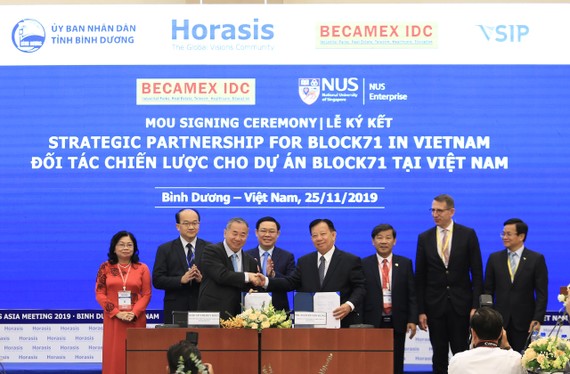 Phó Thủ tướng Vương Đình Huệ (hàng sau, thứ 3 từ trái sang) cùng lãnh đạo tỉnh Bình Dương chứng kiến lễ ký kết giữa Becamex IDC và các đối tác