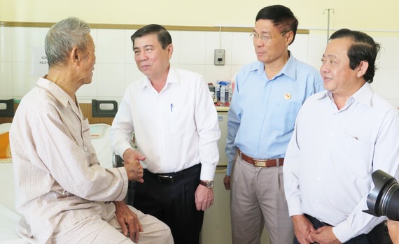Chủ tịch UBND TPHCM Nguyễn Thành Phong ân cần thăm hỏi đồng chí Trần Tài Ba. Ảnh: KIỀU PHONG