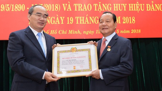 Bí thư Thành ủy TPHCM Nguyễn Thiện Nhân trao huy hiệu 50 năm tuổi Đảng cho đồng chí Lê Thanh Hải. Ảnh: VIỆT DŨNG