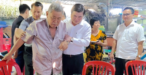 Chủ tịch UBND TPHCM ân cần thăm hỏi sức khỏe ông Huỳnh Quang Hải và  gia đình ông. Ảnh: KIỀU PHONG 