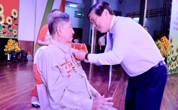 Đồng chí Nguyễn Thành Phong trao Huy hiệu 70 năm tuổi Đảng cho Đảng viên Quận Thủ Đức. Ảnh: KIỀU PHONG
