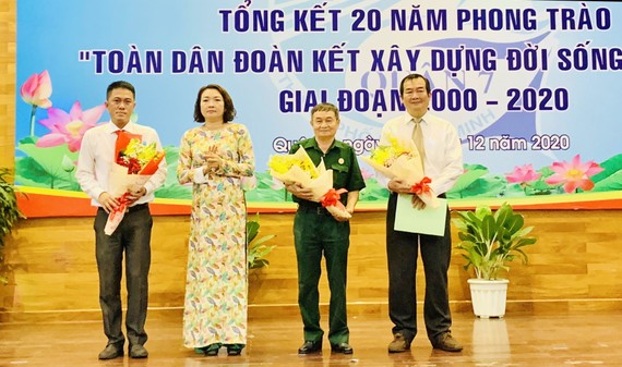 Phó Chủ tịch UBND quận 7 Bùi Thị Ngọc Hiếu (thứ 2, từ trái sang), tặng hoa cho đại diện các đơn vị có thành tích tốt trong thực hiện phong trào “toàn dân đoàn kết xây dựng đời sống văn hóa”. Ảnh: HOÀNG MINH