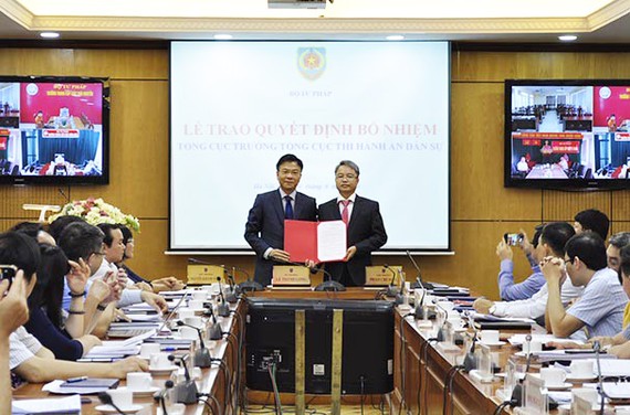 Bộ trưởng Bộ Tư pháp Lê Thành Long trao quyết định cho tân Tổng cục trưởng Tổng cục Thi hành án dân sự Nguyễn Quang Thái 
