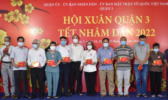 Phó Bí thư Thành ủy TPHCM Nguyễn Hồ Hải trao quà cho các gia đình chính sách. Ảnh: ĐÌNH LÝ