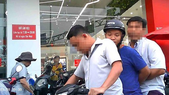 Thanh tra Công an TPHCM đưa bảo vệ dân phố Nguyễn Hoàng Minh về làm việc. Ảnh: PLO