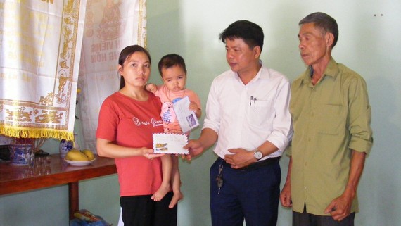 Chủ tịch UBND xã Nga Phượng Ngô Đăng Khoa trao tiền của bạn đọc Báo SGGP cho mẹ con chị Hoàng Thị Oanh