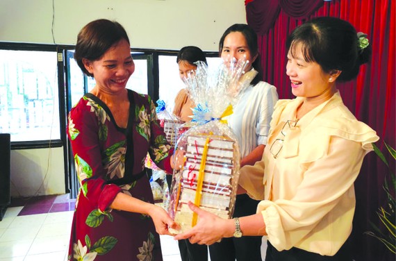 市綜合科學圖書館傳媒部門主任阮氏如莊(左一)向各校贈送書籍。