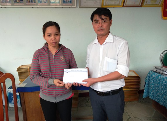 Đại diện Báo SGGP tại miền Trung trao tiền hỗ trợ cho chị Nguyễn Thị Nga