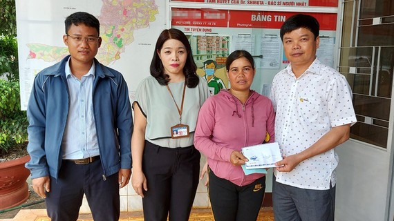 Ông Nguyễn Hữu Quế (bên phải), Chủ tịch UBND TP Pleiku  phối hợp với đại diện Báo SGGP (bên trái) cùng UBND phường Trà Bá (thứ 2 từ trái qua) trao tiền hỗ trợ của bạn đọc Báo SGGP cho gia đình em Liên