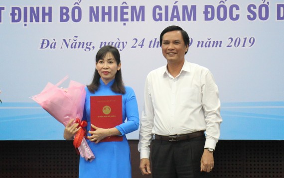 Ông Trần Văn Miên, Phó chủ tịch UBND TP Đà Nẵng trao quyết định và tặng hoa chúc mừng cho bà Trương Thị Hồng Hạnh