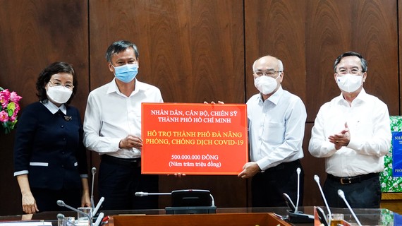 Đồng chí Phan Nguyễn Như Khuê trao bảng tượng trưng hỗ trợ quỹ phòng chống dịch cho đồng chí Đoàn Ngọc Hùng Anh