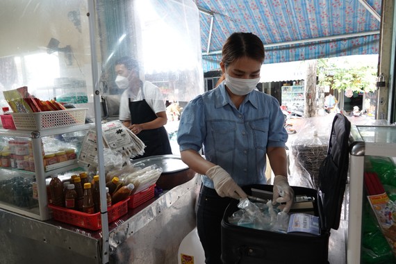 Chuyên viên An toàn thực phẩm- Ban quản lý các chợ quận Sơn Trà kiểm tra chất lượng thực phẩm tại một quầy hàng thuộc chợ Nại Hiên Đông