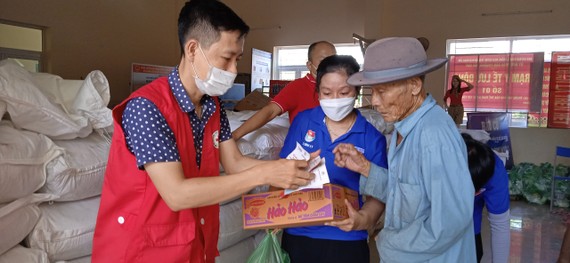Nhân viên Hội Chữ thập đỏ hỗ trợ cấp phát nhu yếu phẩm cho người dân khó khăn