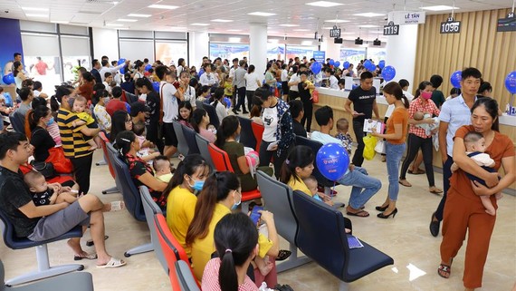 Người dân chờ đến lượt tiêm chủng cho trẻ sáng 11-7 tại Trung tâm VNVC Thanh Hóa
