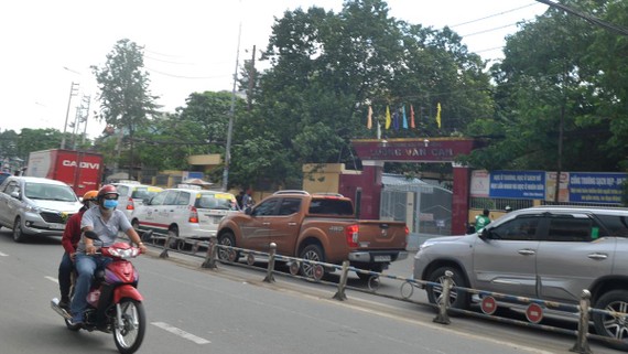 Phương tiện giao thông nối đuôi nhau chạy ngang qua cổng Trường THPT Lương Văn Can, quận 8, TPHCM. Ảnh: THÀNH TRÍ