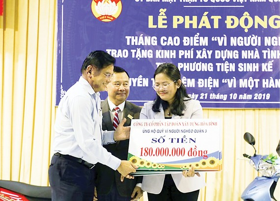 Ông Nguyễn Hữu Hiền - Trợ lý Chủ tịch HĐQT, Giám đốc đối ngoại Hòa Bình trao tặng bảng tiền tượng trưng cho Quỹ Vì người nghèo Quận 3