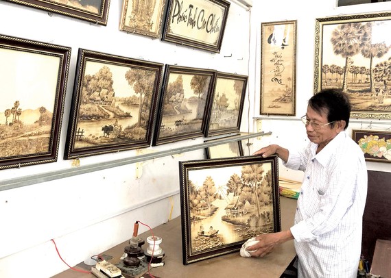 Nghệ nhân Võ Văn Tạng giới thiệu những bức tranh bằng lá thốt nốt