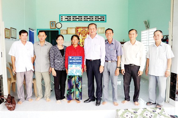 Ông Lưu Hoàng Tân - Chủ tịch, Giám đốc Công ty TNHH MTV Xổ số kiến thiết Đồng Tháp (thứ năm từ trái sang trao nhà tình thương cho hộ gia đình chính sách)