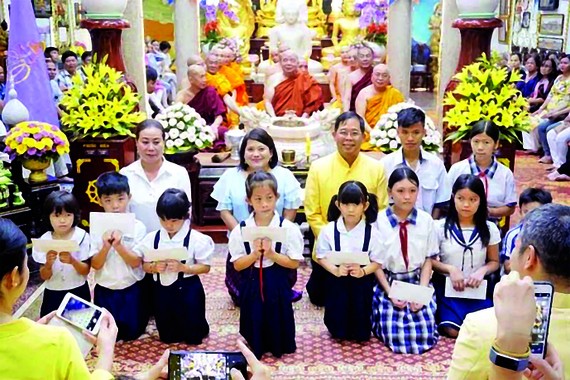 Tổng Lãnh sự Thái Lan tại TPHCM Apirat Sugondhabhirom (áo vàng)  trao học bổng cho học sinh nghèo tại chùa Phổ Minh (TPHCM)