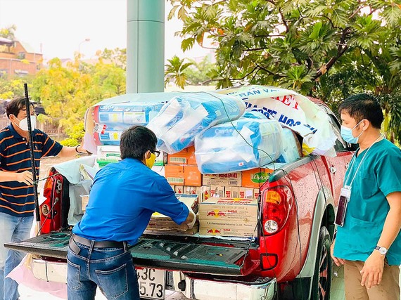 Thành viên Câu lạc bộ Xe bán tải Đà Nẵng đưa hàng hóa, nhu yếu phẩm,  đồ bảo hộ chống dịch đến các khu cách ly. Ảnh: NGUYỄN CƯỜNG