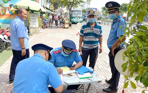 Thanh tra GTVT lập biên bản vi phạm quy định về đảm bảo trật tự an toàn giao thông trên đường Kinh Dương Vương, quận Bình Tân. Ảnh: CAO THĂNG