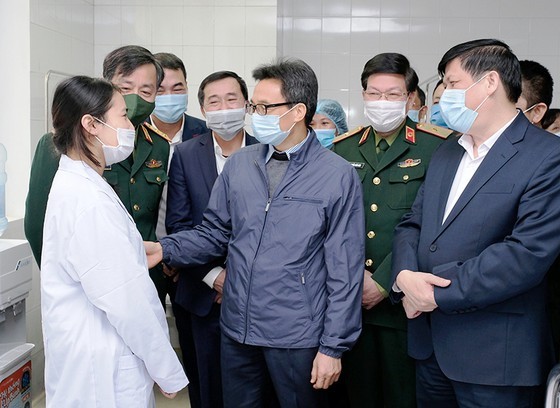 Phó Thủ tướng Vũ Đức Đam và Bộ trưởng Bộ Y tế Nguyễn Thanh Long động viên một tình nguyện viên được tiêm thử nghiệm vaccine ngừa Covid-19 của Việt Nam