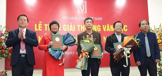 Đồng chí Nguyễn Trọng Nghĩa (bìa trái) và nhà thơ Nguyễn Quang Thiều trao Giải thưởng Văn học 2021 của Hội Nhà văn Việt Nam