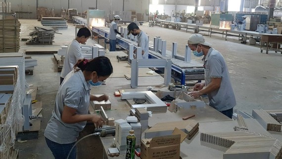 Công nhân công ty sản xuất gỗ Triệu Phú Lộc (Bình Dương) tất bật với các đơn hàng xuất khẩu