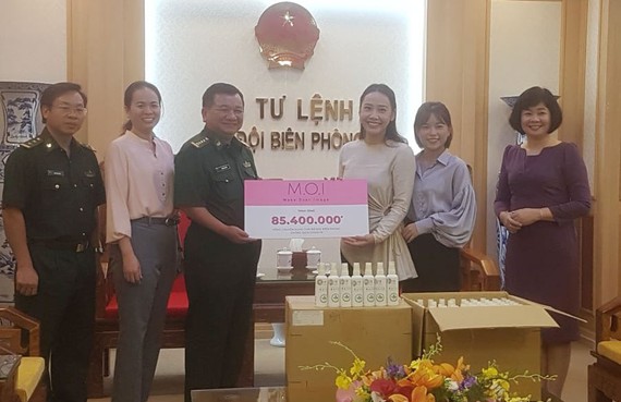 Đại diện Công ty Mỹ phẩm thương hiệu Việt M.O.I Cosmetics trao bảng tượng trưng số tiền tặng Bộ đội biên phòng