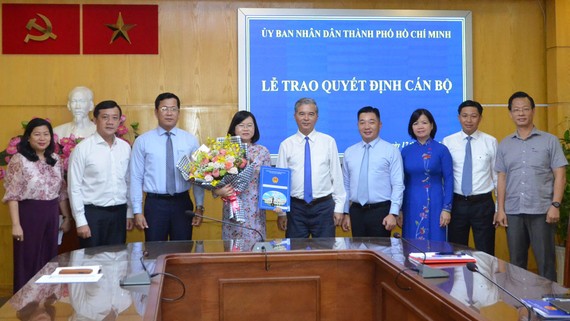 Phó Chủ tịch UBND TPHCM Ngô Minh Châu trao quyết định cho bà Võ Thị Chính. Ảnh: HOÀI NAM