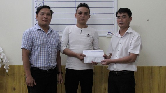 Đại diện Báo SGGP tại miền Trung và chính quyền địa phương trao tiền hỗ trợ cho gia đình cháu Huy 
