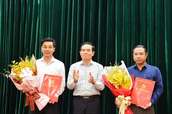 Đồng chí Trần Lưu Quang, Phó Bí thư Thường trực Thành ủy trao quyết định cho đồng chí Nguyễn Anh Tuấn (bên phải) và đồng chí Trần Anh Tuấn (bên trái). Ảnh: VIỆT DŨNG