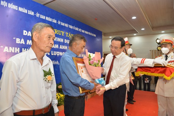 Bí thư Thành uỷ TPHCM Nguyễn Văn Nên trao tặng danh hiệu Mẹ Việt Nam Anh hùng và tặng hoa cho thân nhân các mẹ. Ảnh: CAO THĂNG