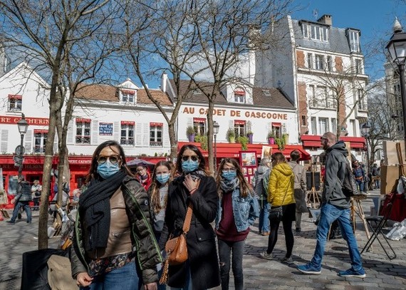 法國巴黎民眾外出時佩戴口罩。