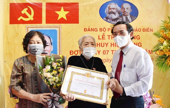2021年11月，市委書記阮文年向黨員莫金菊頒授75年黨齡紀念章。