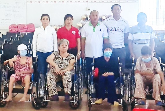理事長鄭成龍(後排左三)等向殘疾人士 贈送輪椅。