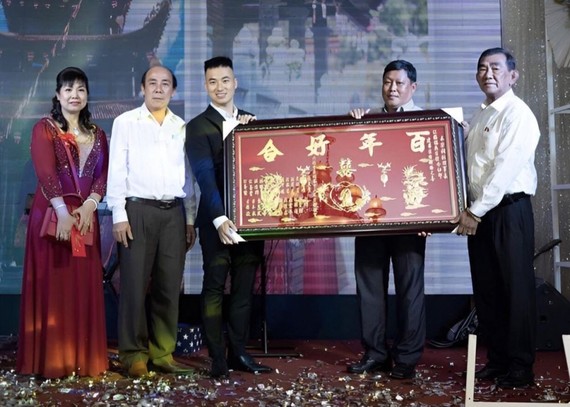 張滿燕（左一）與長子江建昌(左三)接受六桂堂 宗祠贈送祝賀金牌後，並向該宗祠捐款。