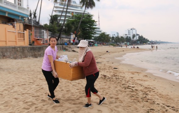 Người dân Phú Quốc tự nguyện nhặt rác tại bãi biển gần cửa sông Dương Đông. Ảnh: QUỐC BÌNH