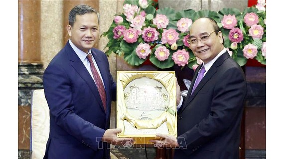 Chủ tịch nước Nguyễn Xuân Phúc tặng quà lưu niệm cho Đại tướng Hun Manet. Ảnh: TTXVN