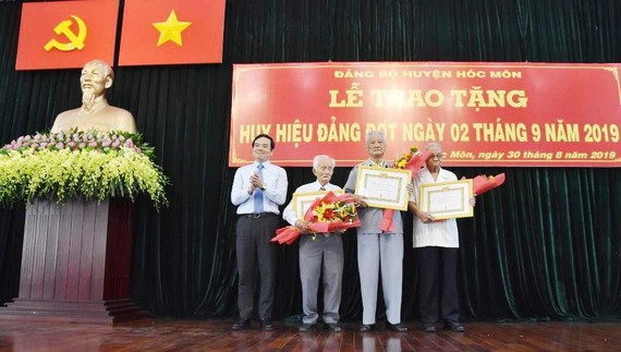 Đồng chí Trần Lưu Quang chúc mừng các đồng chí nhận Huy hiệu 70 năm tuổi Đảng
