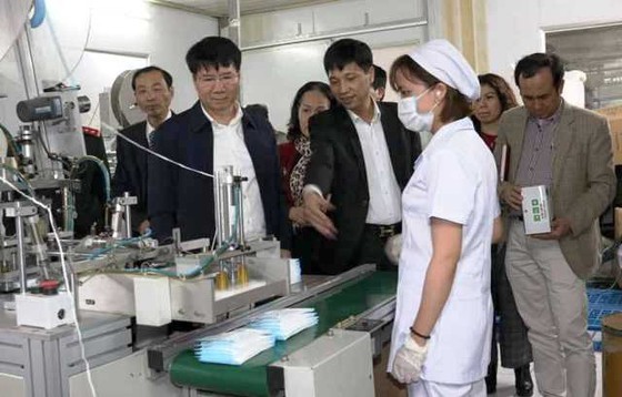 A delegation from the Ministry of Health visits a medical face mask manufacturer. (Photo: SGGP)