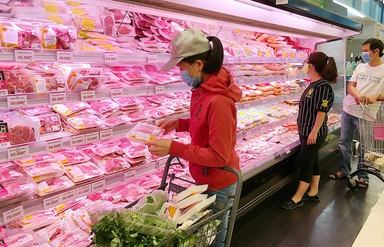 Consumers buy pork at a supermarket. (Photo: SGGP)
